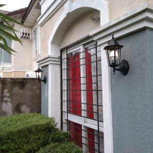 Una ventana en una casa con una lámpara. en Vacation home in Lancaster new city Cavite Philippines en General Trias