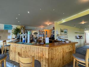 a restaurant with a large wooden counter and chairs at Cosy room with golf & the beach on your doorstep! in Mawgan Porth