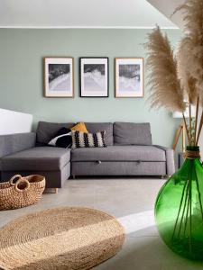 sala de estar con sofá y jarrón verde en Charming Duplex Penthouse Near Valletta., 