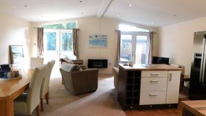 a living room with a table and chairs and a dining room at The Lodge, Alder Country Park in North Walsham