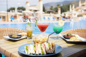 a table with plates of sandwiches and chips and drinks at Ramada Costa Adeje Apartment in Adeje