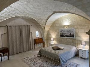 1 dormitorio con 1 cama en una pared de piedra en Suite Cavour Luxury Home Taranto, en Taranto