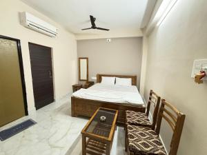 ICHHAMATI HOTEL AND RESTAURANT في Hāsnābād: غرفة نوم بسرير وطاولة وكراسي