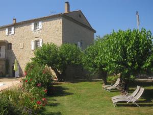 two lawn chairs sitting in the grass in front of a building at Mas de la Garrigue in Les Vans