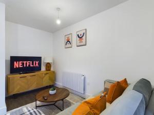a living room with a couch and a tv at The Grove King bed Wi-Fi EV Charger in Cheltenham