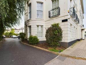 a white building with a balcony on a street at The Grove King bed Wi-Fi EV Charger in Cheltenham