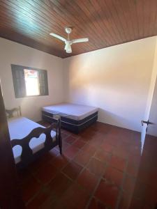 a room with two beds and a ceiling fan at Casa para alugar in Guarujá