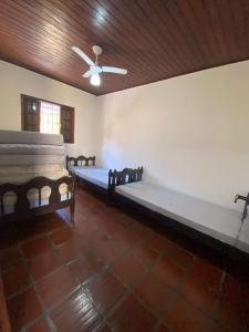 a room with two beds and a ceiling at Casa para alugar in Guarujá