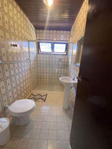 a bathroom with a toilet and a sink at Casa para alugar in Guarujá