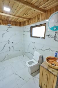 a bathroom with a toilet and a sink at Himalayan Cedar Nest in Sainj