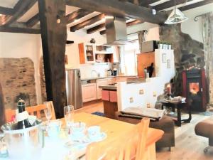 una cucina e una sala da pranzo con tavolo e cucina di Wellness-Ferienhaus Maifelder Uhlenhorst a Gappenach