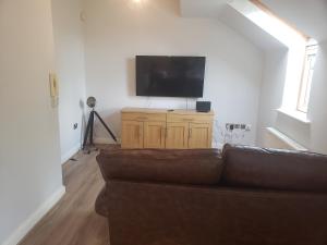 uma sala de estar com um sofá e uma televisão de ecrã plano em Whispering heights em Manchester