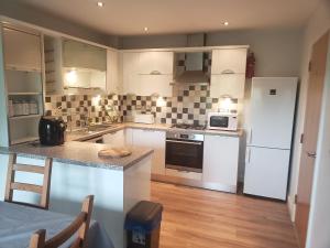 a kitchen with white appliances and a counter top at Whispering heights in Manchester