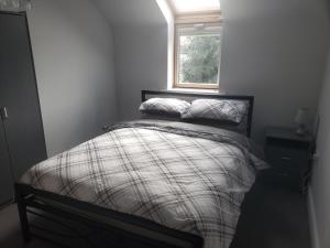 a small bedroom with a bed with a window at Whispering heights in Manchester