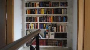 une étagère remplie de livres à côté d'un escalier dans l'établissement Casa Diana Locarno-Cugnasco, à Locarno
