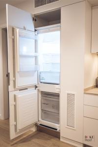 an empty refrigerator with its door open in a kitchen at CASTILLA LUXURY A Apartments in Madrid