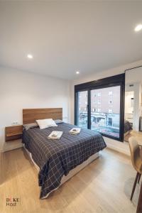 a bedroom with a bed and a large window at CASTILLA LUXURY A Apartments in Madrid