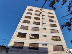 un edificio alto y blanco con balcones. en EDIFICIO ALVARADO en Salta