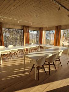 a group of tables and chairs in a room with windows at Yggdrasil farmhotel retreat & spa in Straumsbukta