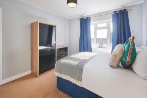 1 dormitorio con 1 cama con cortinas azules y ventana en Host & Stay - Tibshelf House, en Tibshelf