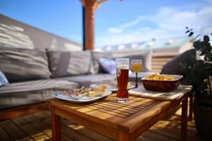 a table with food and a glass of beer at Dúplex Bornoi in Vinarós