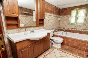 een badkamer met een wastafel, een toilet en een bad bij Timfea Chalet in Tsepelovo