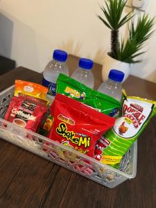 a basket with snacks and water bottles on a table at Little Fox Nest at KLIA Sepang and Gamuda SplashMania in Sepang