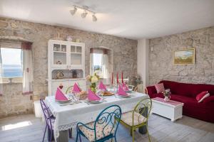 a living room with a table with pink napkins on it at Holiday home Fetiva Makar in Makarska +35 photos