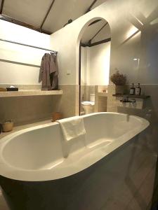 y baño con bañera blanca grande. en Utopua Resort ยูโทปัวว์ รีสอร์ท, en Pua