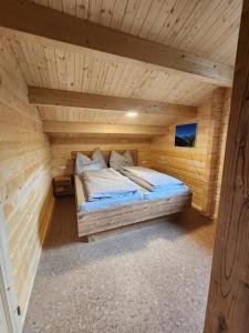 uma cama num quarto de madeira num chalé de madeira em Lipphütte Top Lage mit traumhafter Aussicht em Rauris