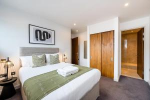 a bedroom with a large white bed and a wooden door at Host & Stay - The Waterfront Hideaway in Liverpool