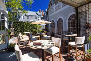 un patio con mesa, sillas y sombrilla en Pilgrim House, en Provincetown