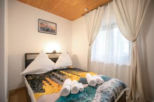 una camera da letto con un letto e asciugamani bianchi di Alpina Haus a Oberammergau