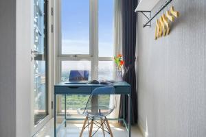 una scrivania blu con una sedia di fronte a una finestra di Sonrisa by Kozystay - Studio - Ocean View - PIK a Giacarta