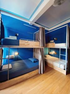 Ha Giang Safari Hostel & Motorbikes في ها زانغ: غرفة بسريرين بطابقين مع جدران زرقاء