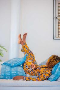 a woman laying on a bed with her arms in the air at Killi Bohemian Luxury in Moshi
