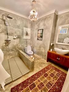 a bathroom with a tub and a toilet and a sink at Killi Bohemian Luxury in Moshi