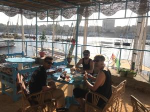a group of people sitting at a table eating food at Awi Guest House in Aswan +98 photos