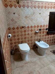 y baño con aseo y lavamanos. en Sardinia House, en Villamassargia