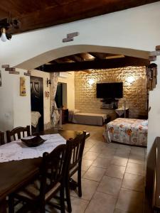una sala de estar con mesa y sillas y una habitación con sofá en Sardinia House, en Villamassargia