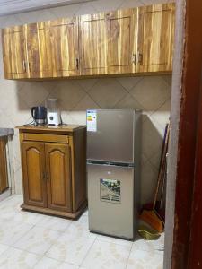 cocina con nevera y armarios de madera en Appartement a hedzranawoe, en Lomé