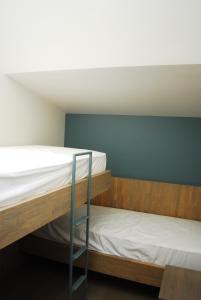 1 dormitorio con 2 literas y techo blanco en B&B Het Schaliënhof en Veurne
