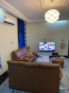 sala de estar con sofá y TV de pantalla plana en Appartement a hedzranawoe, en Lomé