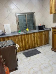 una cocina con fregadero y microondas en una encimera en Appartement a hedzranawoe, en Lomé