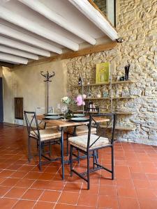 a table and chairs in a room with a stone wall at Crocoloft Nimes Centre in Nîmes