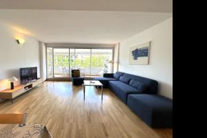 a living room with a blue couch and a tv at Lets Holidays Tossa de Mar Ancora in Tossa de Mar