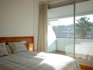a bedroom with a bed and a large window at Lets Holidays Tossa de Mar Ancora in Tossa de Mar