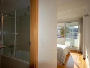 a bedroom with a shower and a bed and a window at Lets Holidays Tossa de Mar Ancora in Tossa de Mar +23 photos