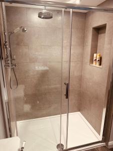 a shower with a glass door in a bathroom at Brabands Cottage Rye in Iden