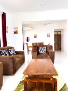 a living room with two couches and a coffee table at Kijiji Villas Nungwi in Banda Kuu